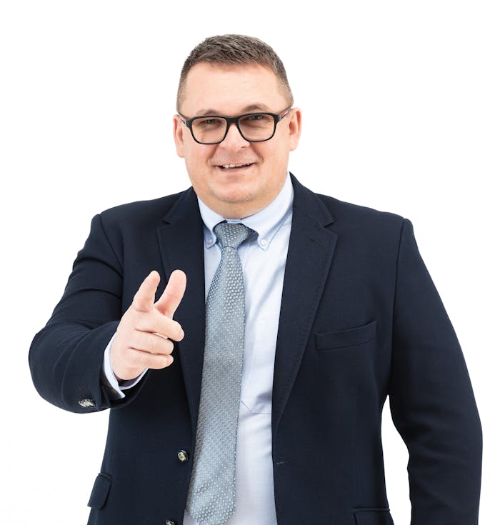 Professional businessman in suit smiling and pointing forward on white background.